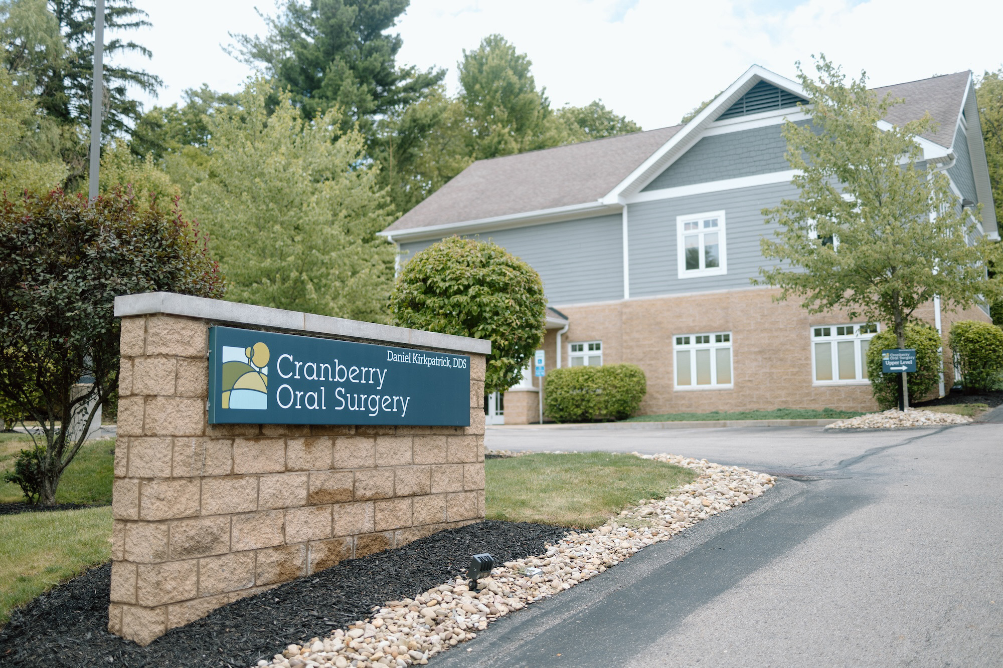 The image shows a building with a sign that reads  Cranberry Oral Surgery  in front of it, indicating the name and purpose of the facility.