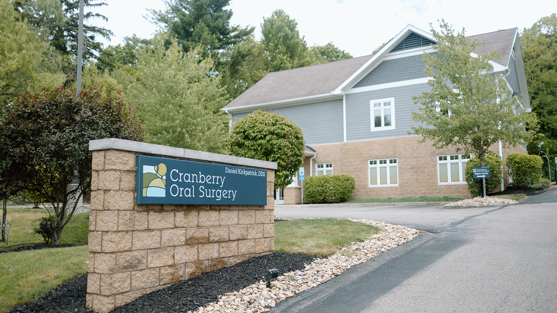 The image shows a sign for Cramer Dental Clinic in front of a building with a sign that reads  Cramer Dental Clinic  and a brick entrance.