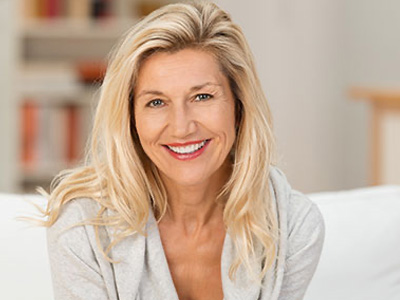 A woman with blonde hair and a smile, posing for a portrait.