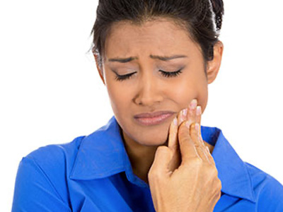 A woman in a blue shirt, with her eyes closed and hand on her chin, appears to be in deep thought or contemplation.